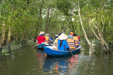 Fototapeta na wymiar Tourism rowing boat in cajuput forest in floating water season in Mekong delta, Vietnam