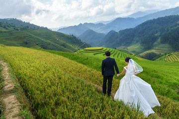 Terraced rice field in Mu Cang Chai, Vietnam, with happy travel couple