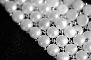 White pearl necklace on a dark background close up. Black and white