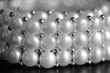 White pearl necklace on a dark background close up. Black and white