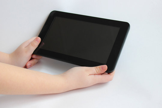 The Child Is Holding A Tablet Computer