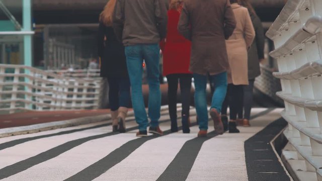 Group Of People Strolling On A Designated Modern Striped Pedestrian Walkway In Amsterdam.