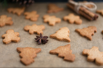 Gingerbread cookies with spices. Gingerbread cookie man and Christmas trees. Festive Christmas baking. Winter background