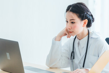 Portrait doctor women sitting working on note clipboard in medical office