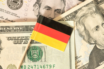 Flagge von Deutschland und Dollar Geldscheine im Hintergrund