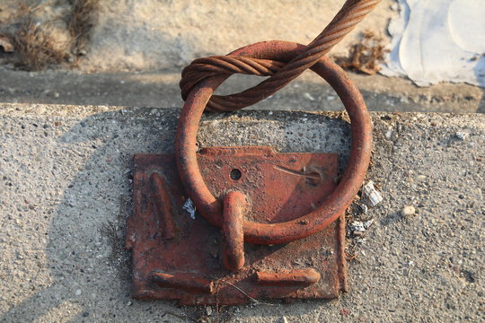 Metal anchor on marina dock.
