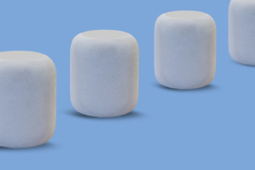 Wireless speakers for listening to music in a row on a blue background. Modern technologies.