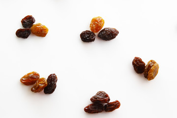 Golden raisins and black raisins on white background
