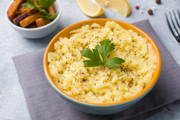 Mashed potatoes with herbs, croutons and lemon in a plate on napkins.