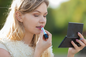 Woman applying red lipstick