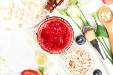Homemade skincare exfoliation with berry extract & rolled oats. Red berry paste in jar top view with natural ingredients. 