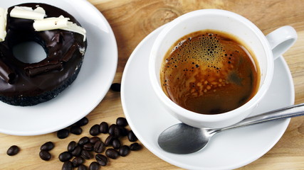 Americano or espresso coffee on the wood table with roasted coffee beans