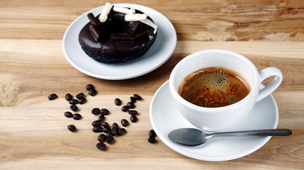 Americano or espresso coffee on the wood table with roasted coffee beans