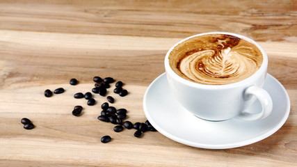 Cappuccino and latte art on the wood table. Free hand pouring some milk on the coffee. Morning breakfast with coffee.