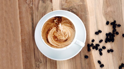 Cappuccino and latte art on the wood table. Free hand pouring some milk on the coffee. Morning breakfast with coffee.