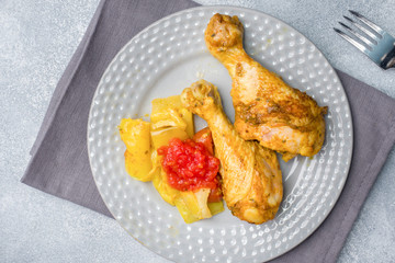 Baked chicken leg Shin with vegetables tomato zucchini on a plate.