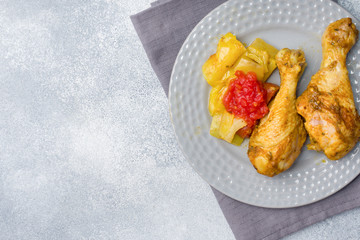 Baked chicken leg Shin with vegetables tomato zucchini on a plate. Copy space