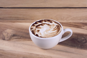Cappuccino and latte art on the wood table. Free hand pouring some milk on the coffee. Morning breakfast with coffee.