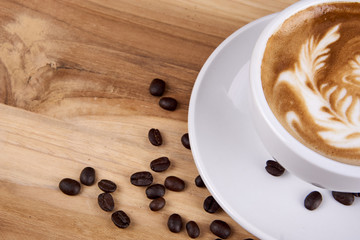 Cappuccino and latte art on the wood table. Free hand pouring some milk on the coffee. Morning breakfast with coffee.