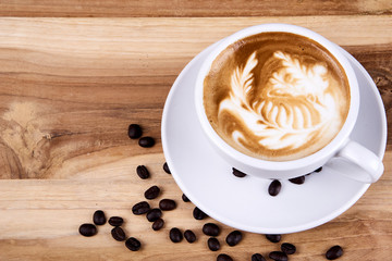 Cappuccino and latte art on the wood table. Free hand pouring some milk on the coffee. Morning breakfast with coffee.