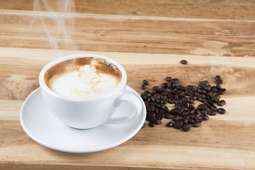 Cappuccino and latte art on the wood table. Free hand pouring some milk on the coffee. Morning breakfast with coffee.