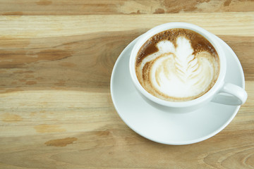 Cappuccino and latte art on the wood table. Free hand pouring some milk on the coffee. Morning breakfast with coffee.