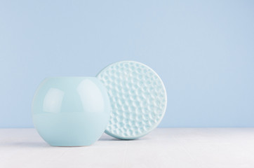 Fashion home decor in modern elegant style - light soft blue ceramic sphere and circle ribbed bowl on white wood background.