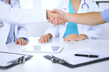 Two doctors shaking hands to each other at meeting. Teamwork and agreement in medicine