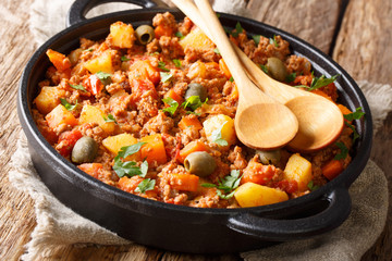Delicious Picadillo cooked from ground beef with vegetables, raisins and spices close-up in a frying pan. horizontal - obrazy, fototapety, plakaty