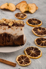 Piece of cake with nuts. Dry lemon wedges, cinnamon stick. Vertical. Light background.