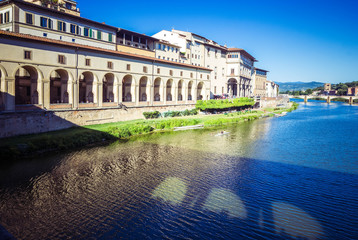 Panoramic view of  Arno River, Vasari Corridor and reflection stone medieval bridge Ponte Vecchio, Florence, Tuscany, Italy.