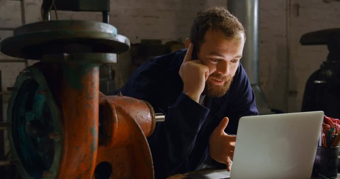 Metalsmith talking on mobile phone in workshop 4k