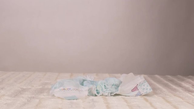 Mother puts a diaper on a white background, napkin, hygiene