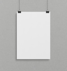 Blank white poster hanging up with clips mockup