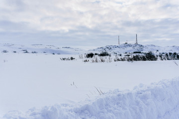 radio cell phone towers on a hill covered with snow in winter in a remote northern village beyond the Arctic Circle