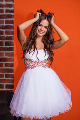 Young beautiful brunette woman in white dress