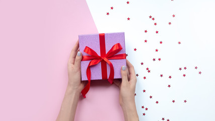 woman holding gift in hands. Pink gift box. Copy space.