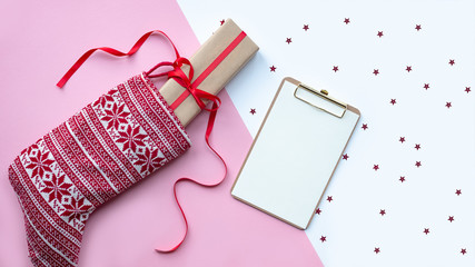 Red christmas sock with gifts on a light background. Christmas background with copyspace.