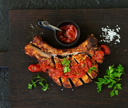 Pork chop on the bone with tomato sauce. view from above.