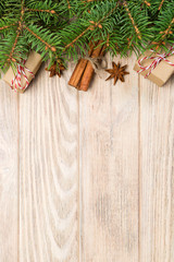 Christmas background with fir tree and gift box on wooden table. Top view with copy space for your design