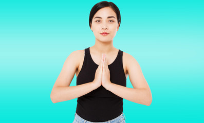 portrait of cute successful asian,korean woman shows namaste gesture on blue background, copy...