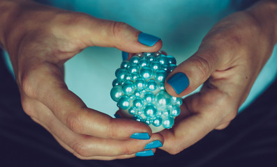 Female hands hold decorated Easter egg. The concept of turquoise color