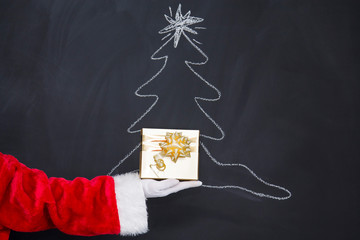 santa claus hand holding gift box, new year and christmas greeting card