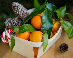 Christmas card with fresh mandarins on wooden background.