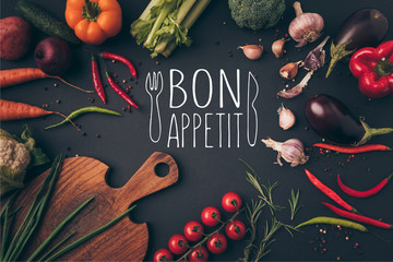 top view of different vegetables and cutting board on table with bon appetit lettering