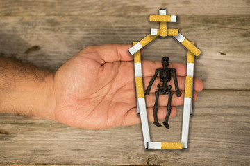 Quit smoking for a healthy life, black human skeleton in coffin made from cigarette butts