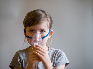 Child making inhalation with mask on his face. Asthma problems concept