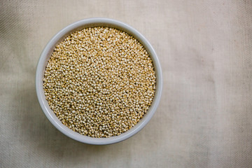 Quinoa in white cup. Raw white quinoa