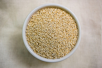 Quinoa in white cup. Raw white quinoa