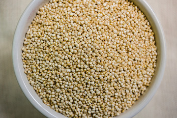 Quinoa in white cup. Raw white quinoa